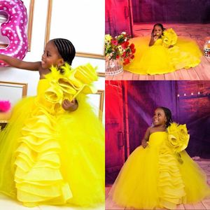 2021 Jolies robes de filles de fleurs jaunes pour les mariages plume une épaule sans manches à volants à plusieurs niveaux robe de bal anniversaire enfants fille robes de concours longueur de plancher tulle