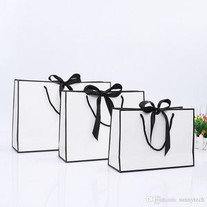 Design créatif grand sac en papier kraft blanc à bordure noire avec poignée sac cadeau en papier nœud papillon pour fête de mariage LX01480