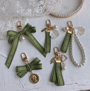 Llavero de diseño Llavero de lujo bolso encanto llavero de coche femenino Encanto de perla cinta verde conchas delicadas llavero pareja colgante regalo