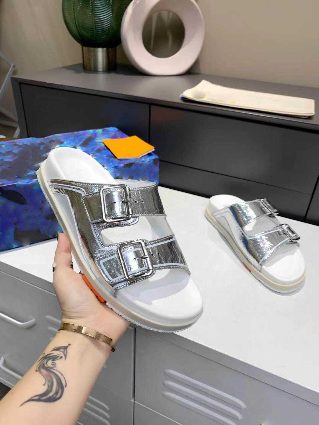 Slippers Men Trainer Mens Buckles Slipper Sandal Slides Beach Shoe Luxury Designer Mule Summer Outdoor Fashion Metallic Leather Size 35-42 SEC0
Slippers Men Trainer Mens Buckles Slipper Sandal Slides Beach Shoe Luxury Designer Mule Summer Outdoor Fashion Metallic Leather Size 35-42 SEC0