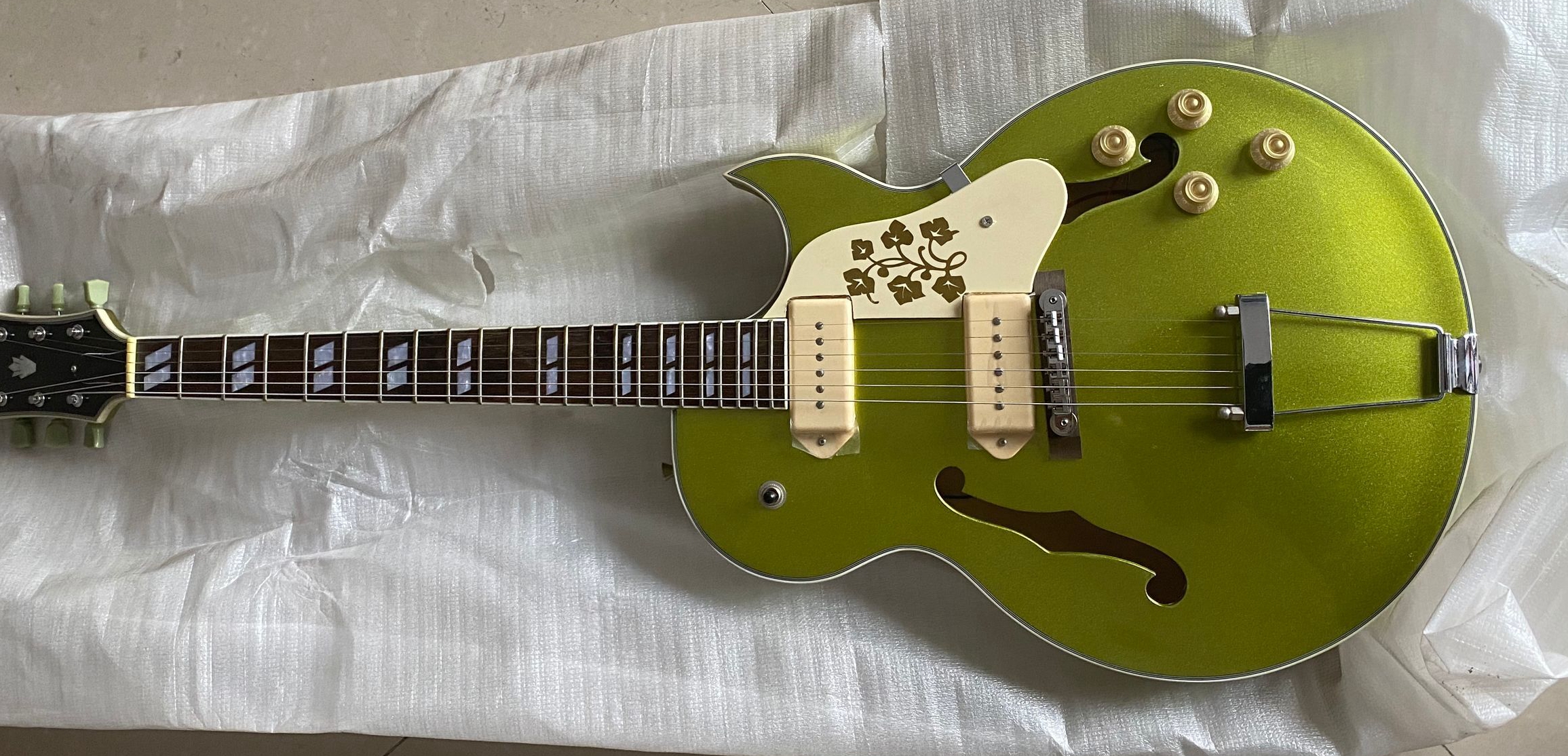 295 Memphis Scotty Moore Metallic Green Gold Hollow Body Electric Guitar Historic Flowers Pickguard, White P90 Pickups, Trapeze Tailpiece, Split Parallelogram Inlay
295 Memphis Scotty Moore Metallic Green Gold Hollow Body Electric Guitar Historic Flowers Pickguard, White P90 Pickups, Trapeze Tailpiece, Split Parallelogram Inlay
