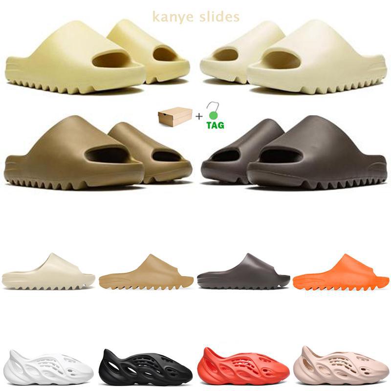 Kanye Slides Men Women Slippers Desert Sand Bone Soot Pure Earth Brown Beige Foam Runner Triple White Black Outdoor Sandals with Box Retro W
Kanye Slides Men Women Slippers Desert Sand Bone Soot Pure Earth Brown Beige Foam Runner Triple White Black Outdoor Sandals with Box Retro W