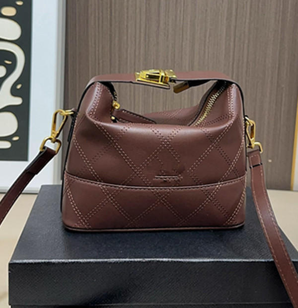 The suede hand-held lunch box bag has a great capacity and is cute to carry and cross over. It features a classic diamond grid and outlines an elegant silhouette.