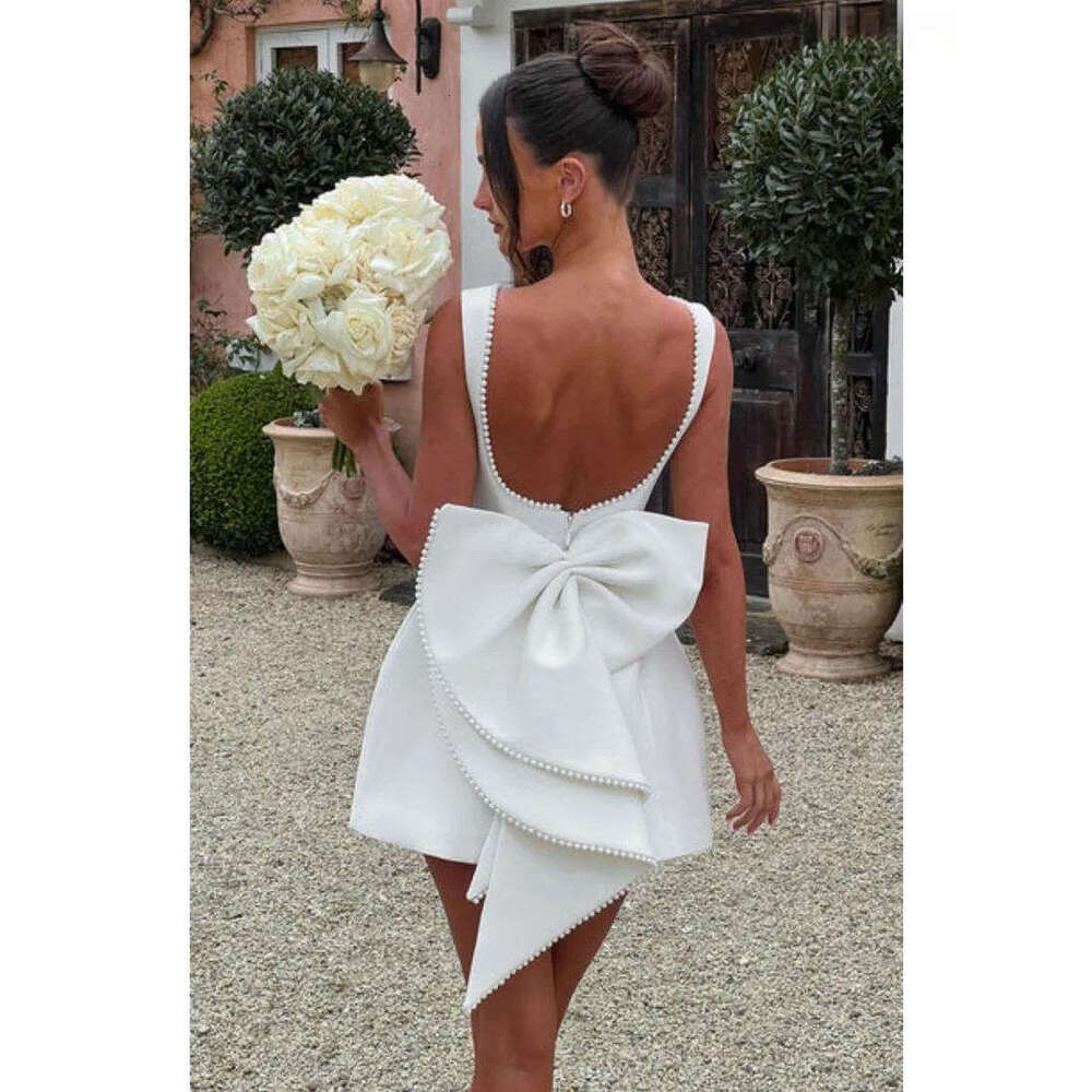 Designer's elegant mini dress with pearl bow details - perfect for parties, weddings, and special occasions