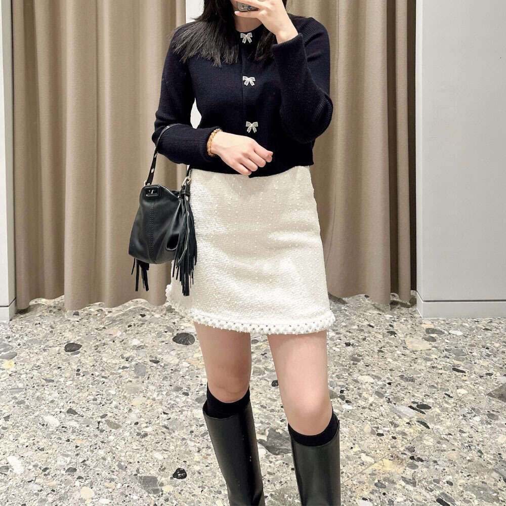 The new women's clothing for the spring and autumn of 2026 adopts a soft knitted cardigan bow and button decoration round neck design