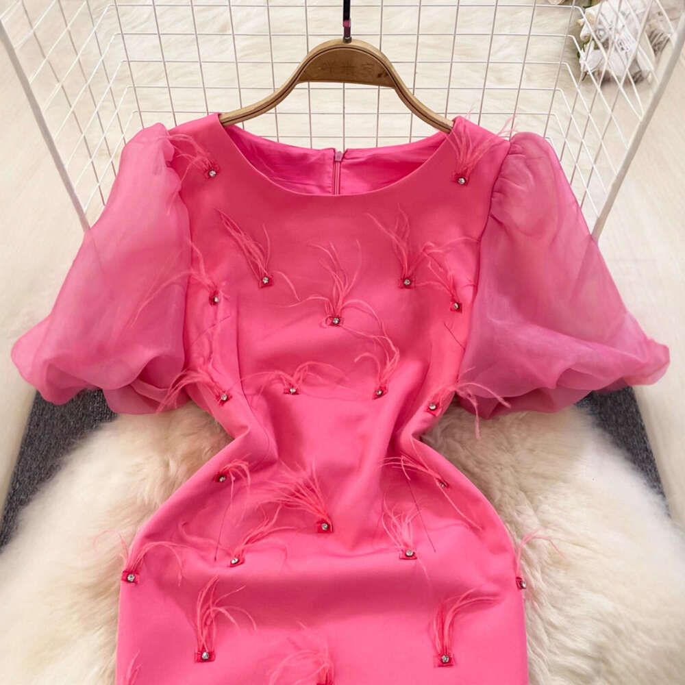 The designer's high-end luxury ladies' dress features bubble sleeves, round neck, and waist cinching design to highlight the mid length cut 