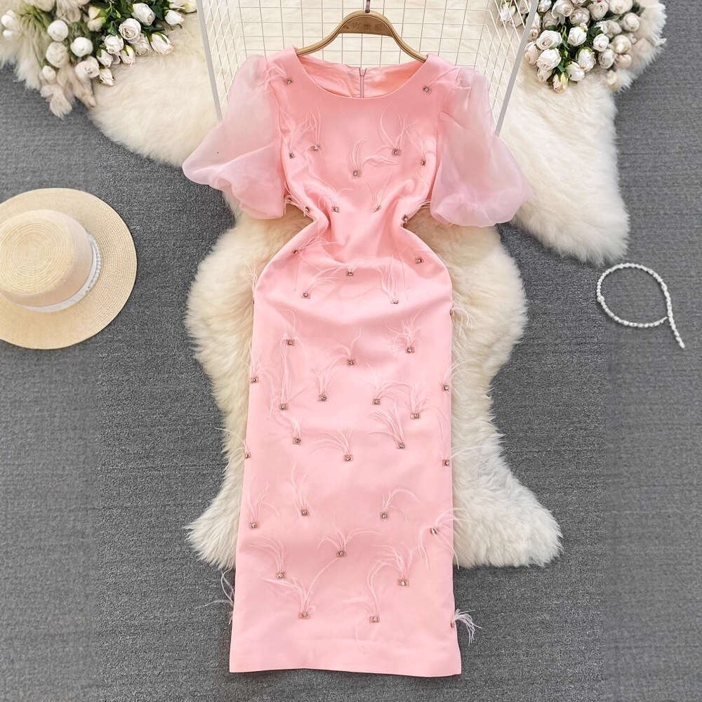 The designer's high-end luxury ladies' dress features bubble sleeves, round neck, and waist cinching design to highlight the mid length cut 