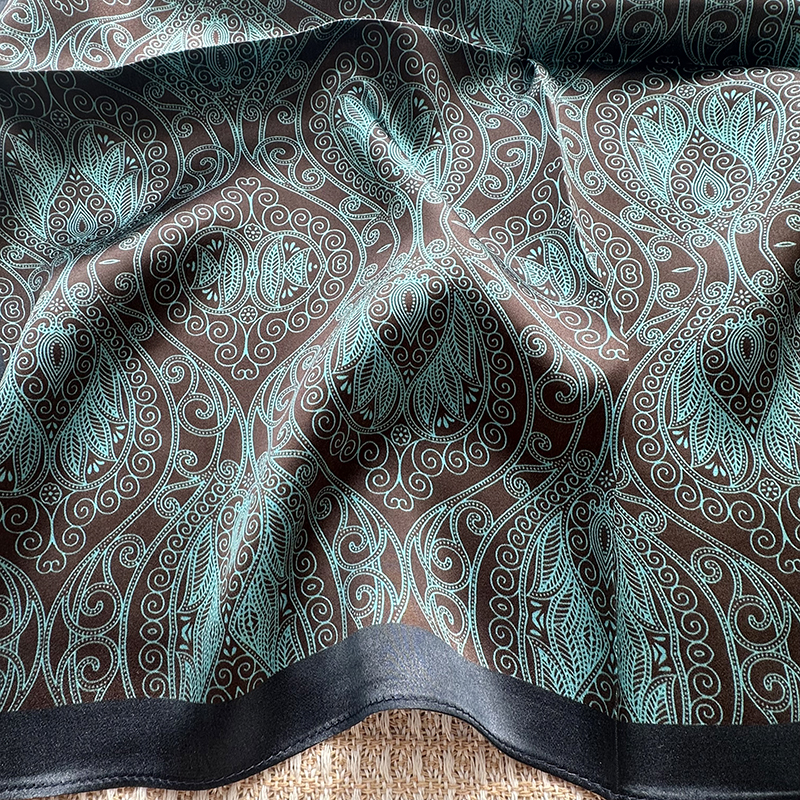 A genuine silk scarf in the green totem style, suitable for women to wear. It offers a fashionable and elegant neck support function. It is a small-si