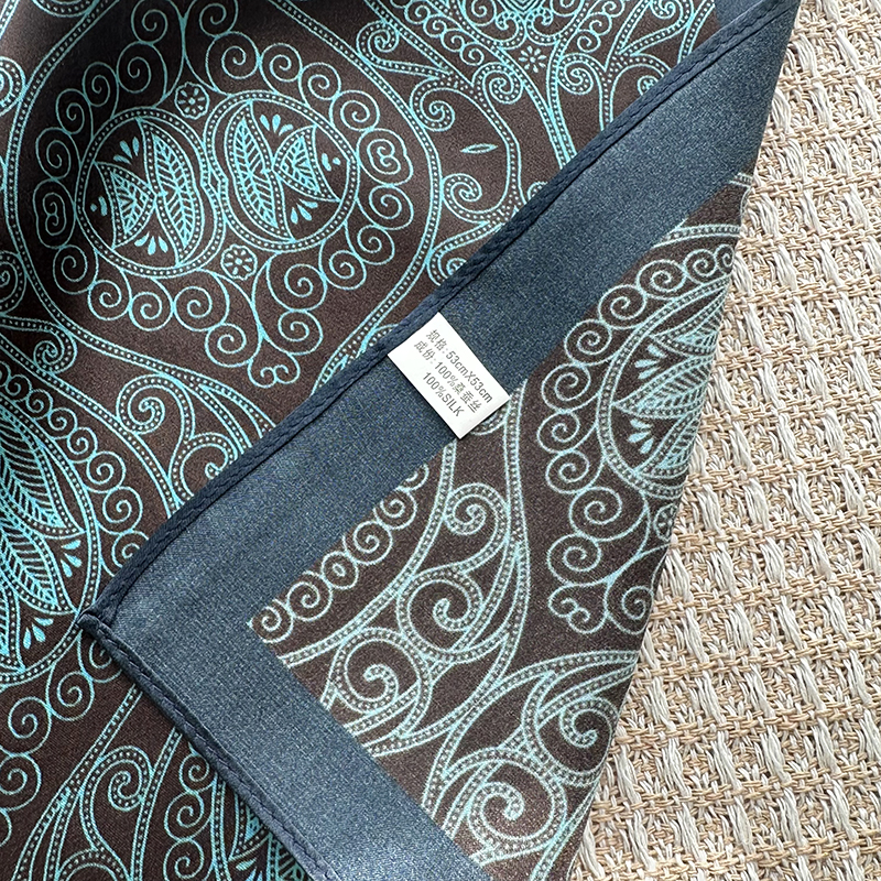 A genuine silk scarf in the green totem style, suitable for women to wear. It offers a fashionable and elegant neck support function. It is a small-si