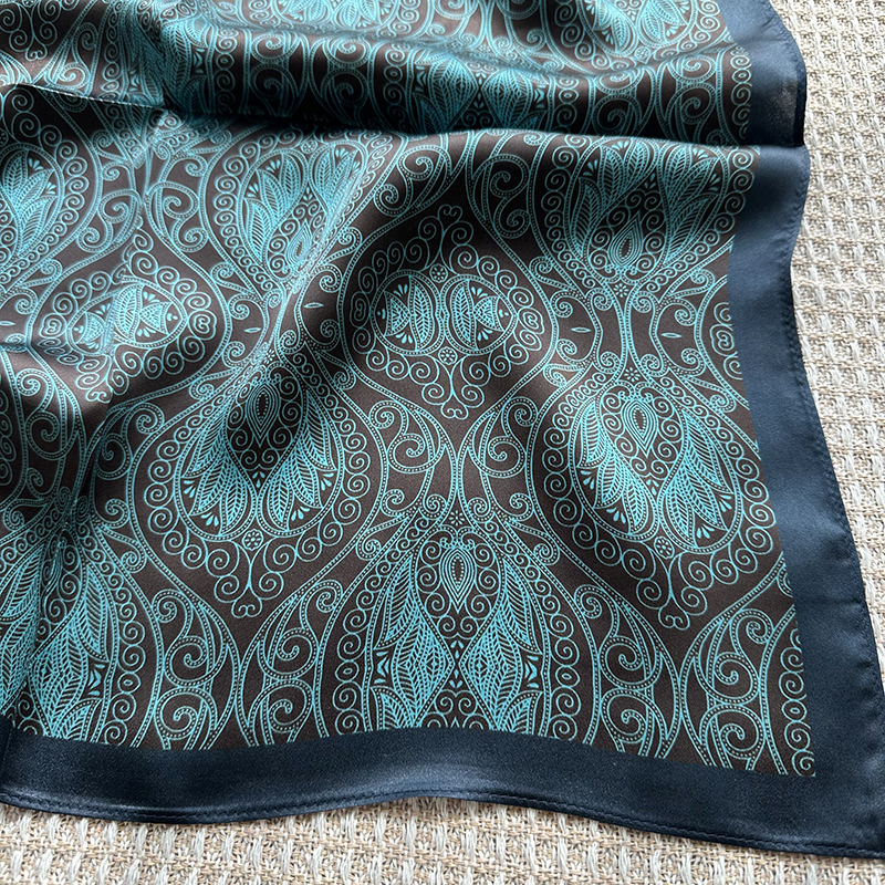 A genuine silk scarf in the green totem style, suitable for women to wear. It offers a fashionable and elegant neck support function. It is a small-si