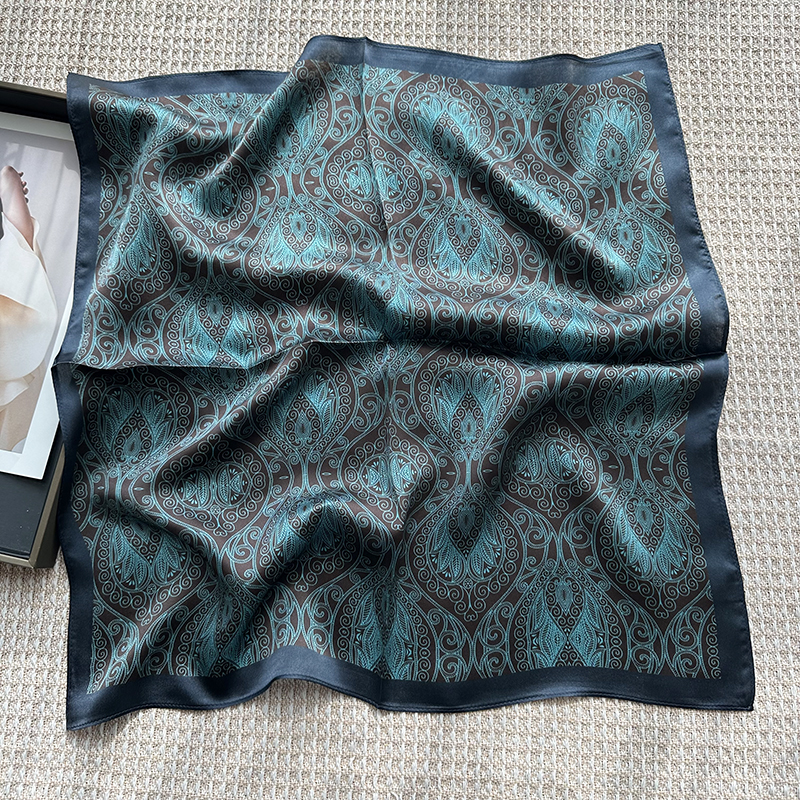 A genuine silk scarf in the green totem style, suitable for women to wear. It offers a fashionable and elegant neck support function. It is a small-si