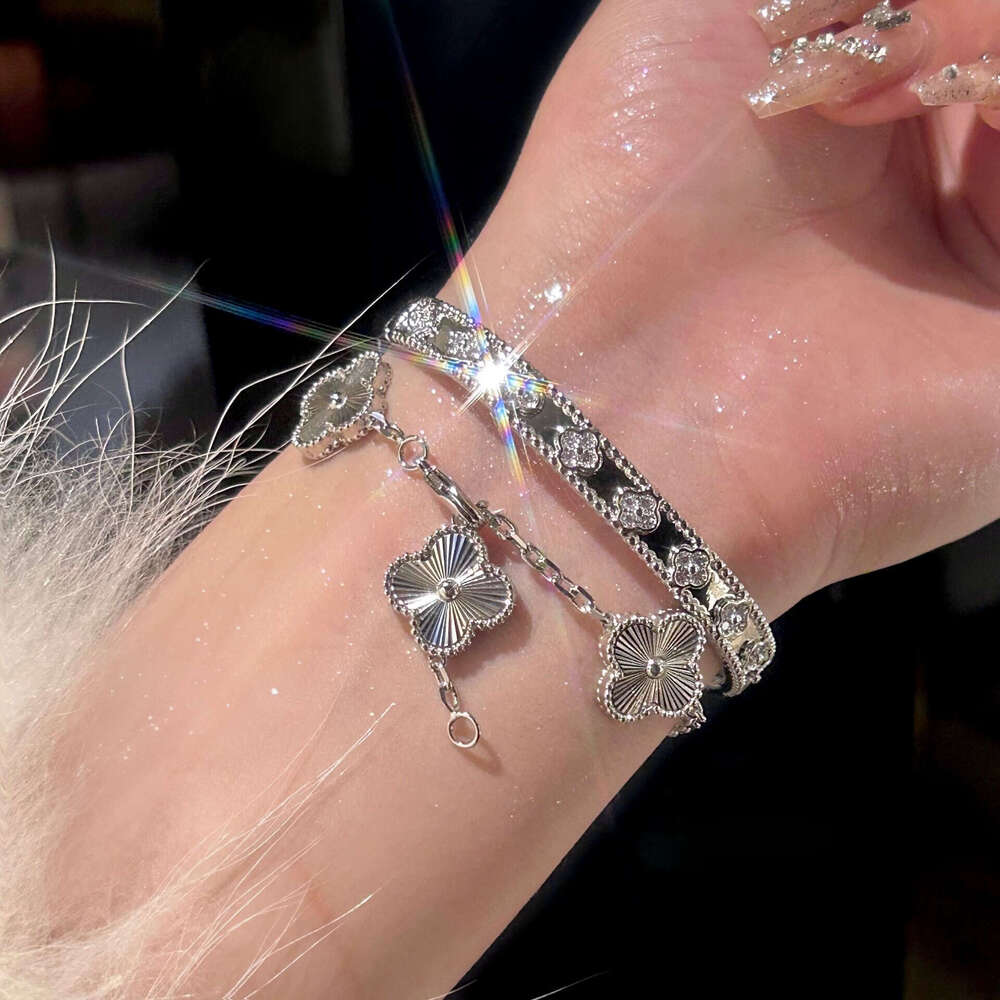 Gold four-leaf clover bracelet with laser kaleidoscope, light luxury, high-end brand, sparkling diamonds, and a sense of sophistication.