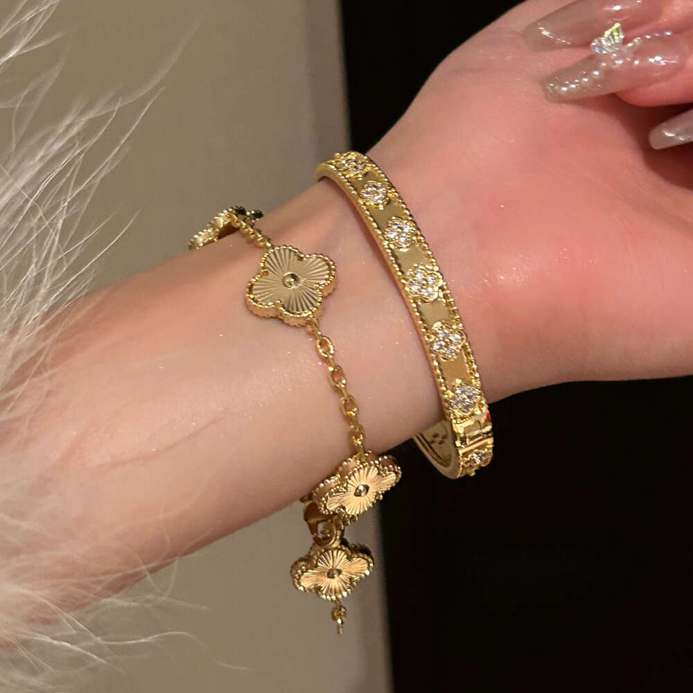 Gold four-leaf clover bracelet with laser kaleidoscope, light luxury, high-end brand, sparkling diamonds, and a sense of sophistication.