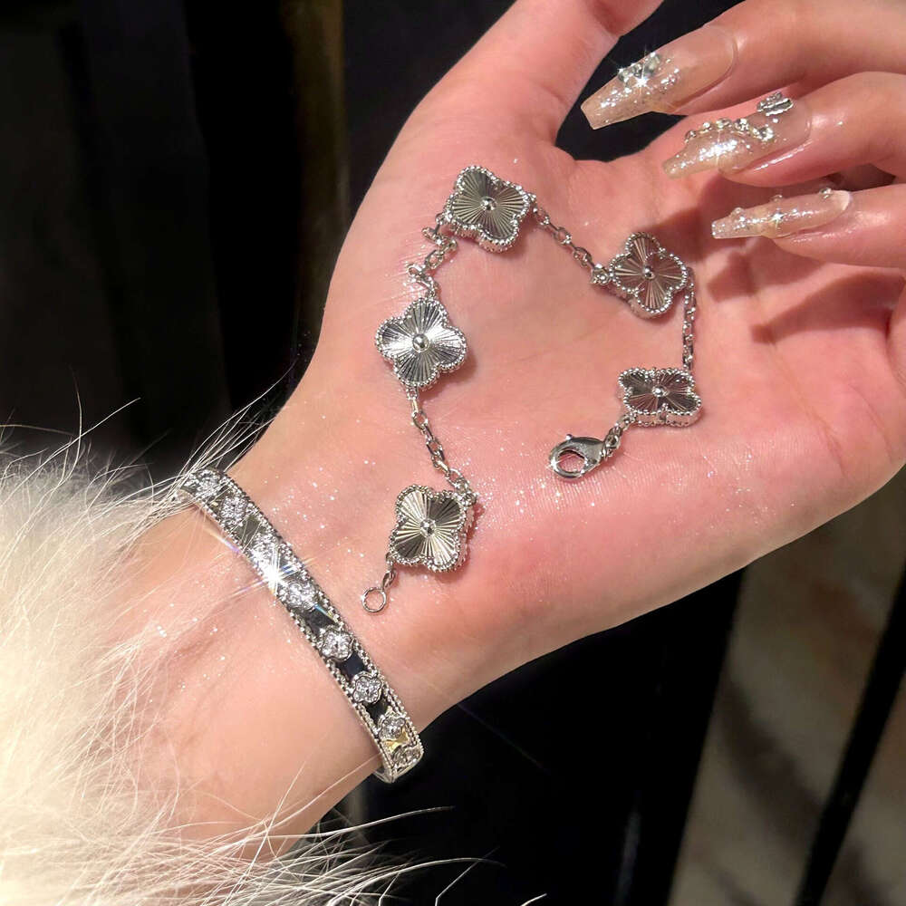 Gold four-leaf clover bracelet with laser kaleidoscope, light luxury, high-end brand, sparkling diamonds, and a sense of sophistication.