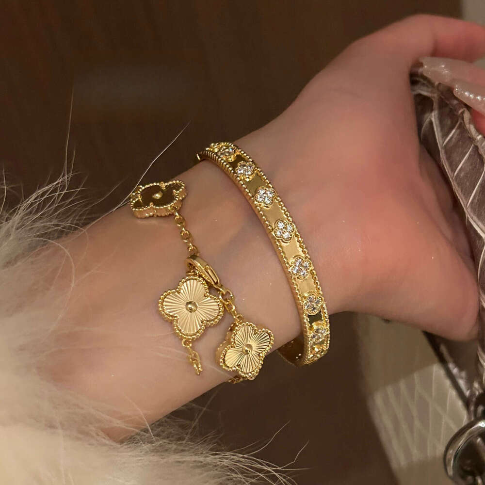 Gold four-leaf clover bracelet with laser kaleidoscope, light luxury, high-end brand, sparkling diamonds, and a sense of sophistication.