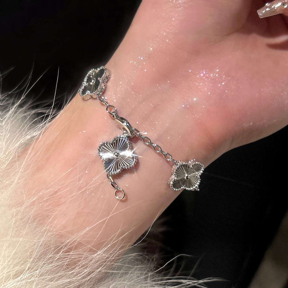 Gold four-leaf clover bracelet with laser kaleidoscope, light luxury, high-end brand, sparkling diamonds, and a sense of sophistication.