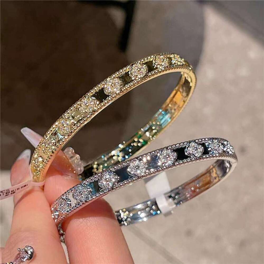 Gold four-leaf clover bracelet with laser kaleidoscope, light luxury, high-end brand, sparkling diamonds, and a sense of sophistication.