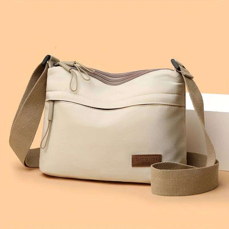 This large-capacity crossbody bag for women features a multi-zipper design and adjustable shoulder straps, making it suitable fo XJ260129