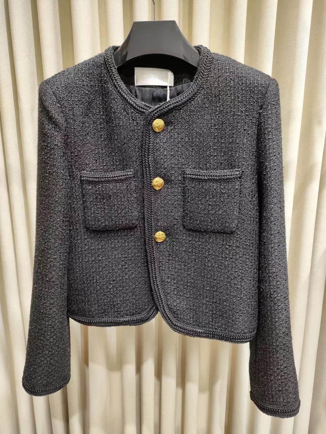The black and gold three button coat features a small and short design that enhances body proportions