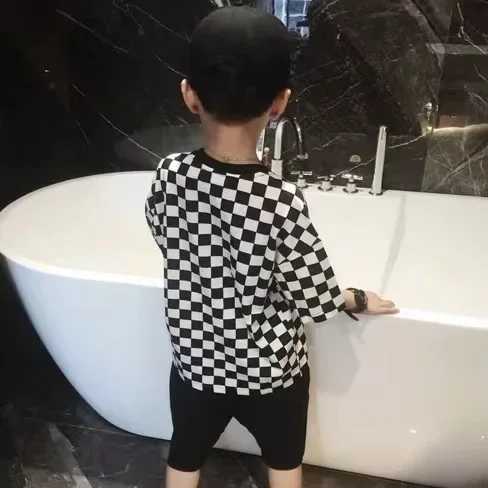 Boys summer childrens cotton T-shirt 2024 new black and white checkerboard grid Korean short sleeved fashionable loose hip-hop T-shirtW240718