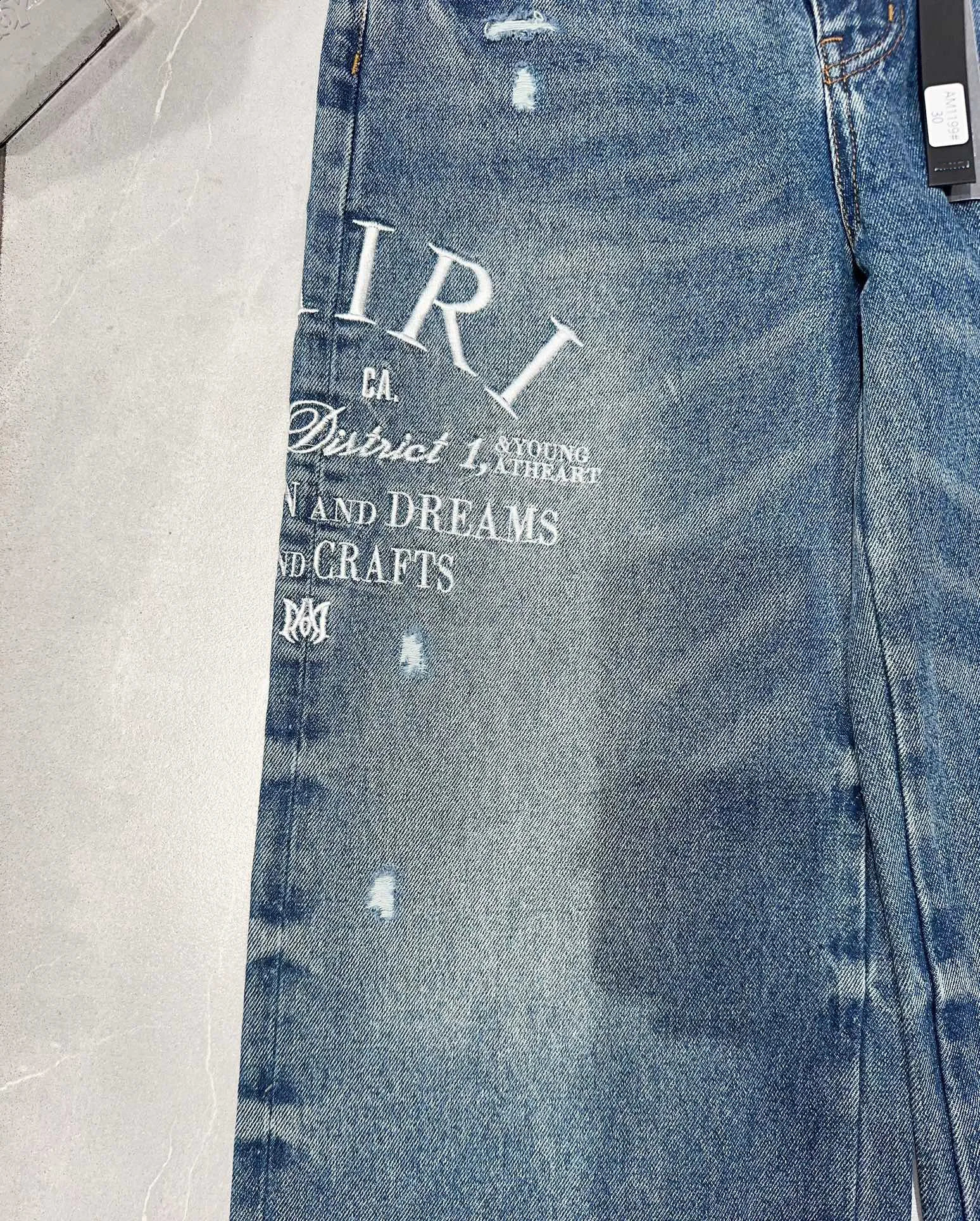 The latest blue wide leg mens tight jeans suitable for pocket denim pants with letter embroidery and tear holes on the knees 240829