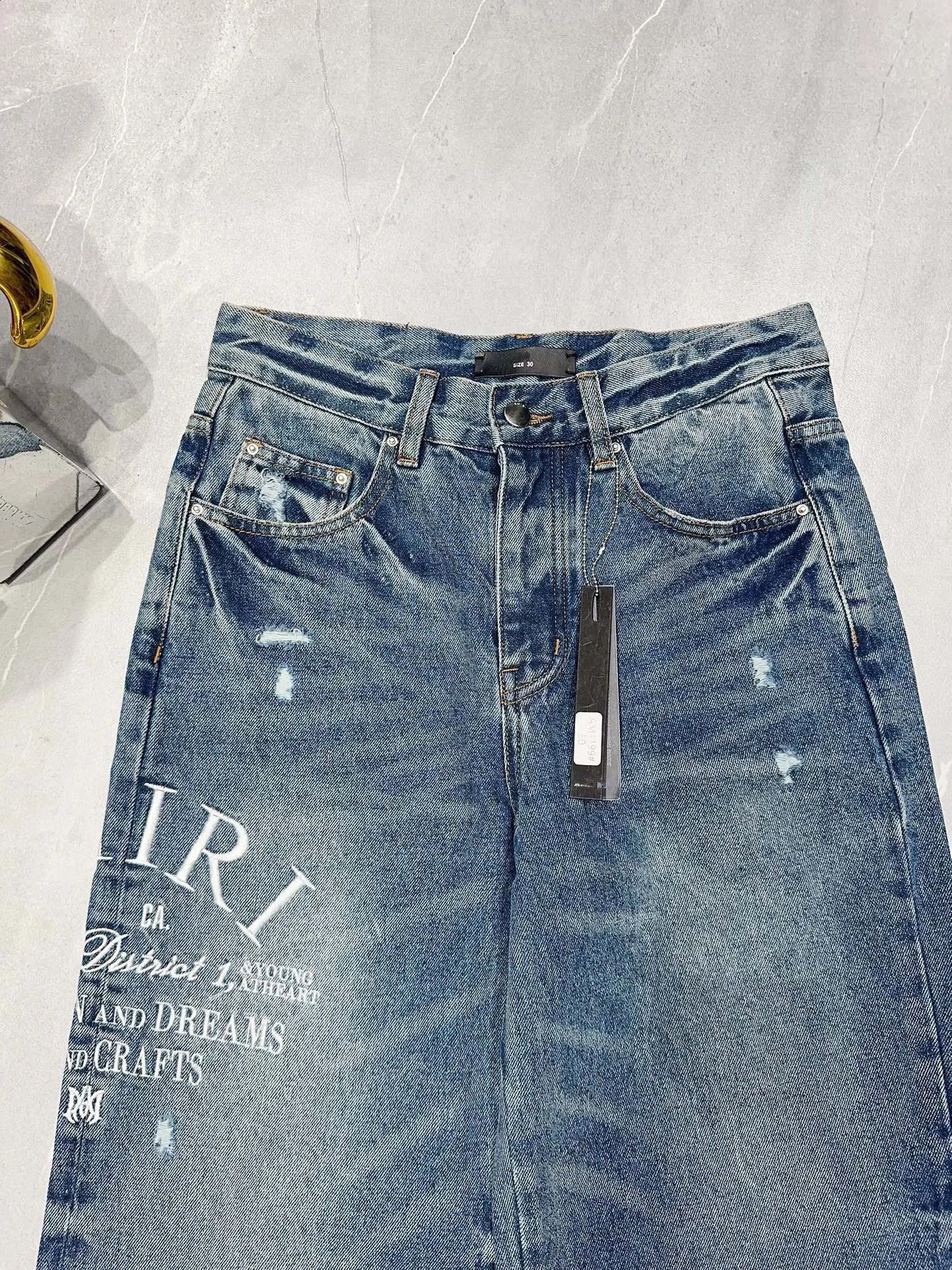 The latest blue wide leg mens tight jeans suitable for pocket denim pants with letter embroidery and tear holes on the knees 240829