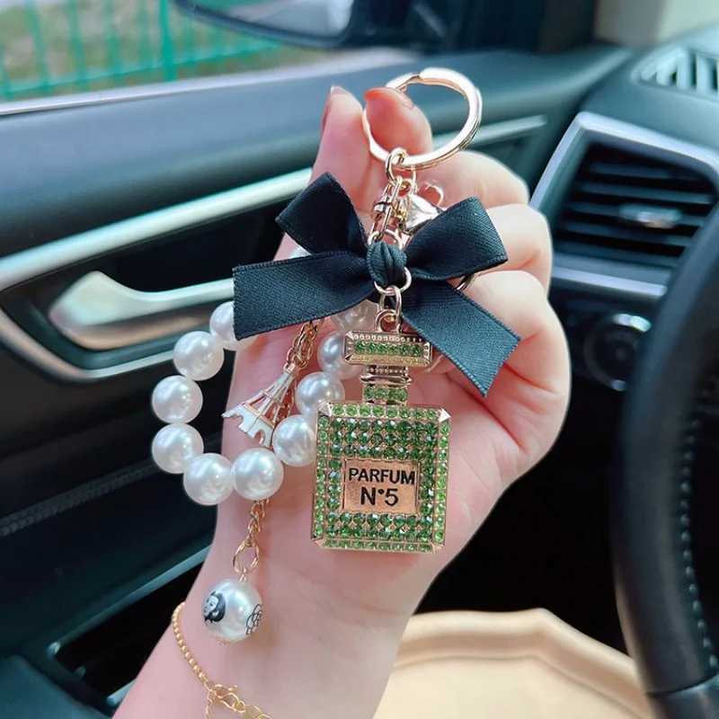 Keychains Lanyards Alloy diamond inlaid bow shaped perfume bottle key chain creative pearl chain pendant bag exit key chain J241010