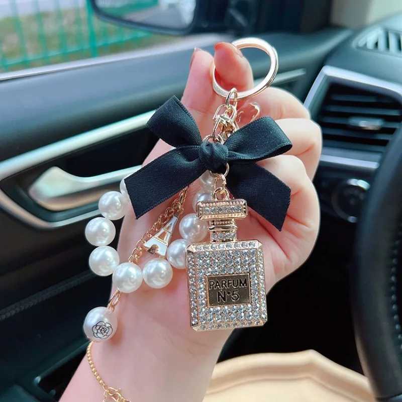 Keychains Lanyards Alloy diamond inlaid bow shaped perfume bottle key chain creative pearl chain pendant bag exit key chain J241010