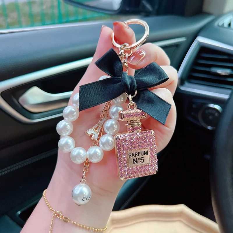 Keychains Lanyards Alloy diamond inlaid bow shaped perfume bottle key chain creative pearl chain pendant bag exit key chain J241010