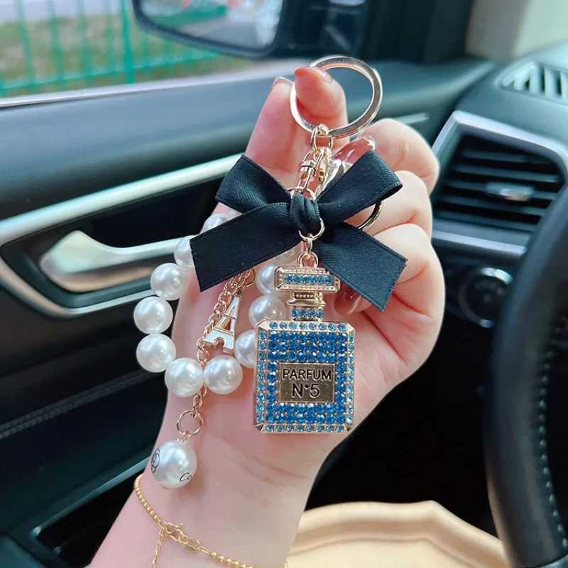 Keychains Lanyards Alloy diamond inlaid bow shaped perfume bottle key chain creative pearl chain pendant bag exit key chain J241010