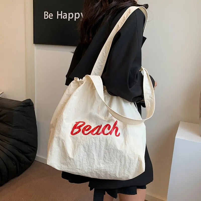 Womens Korean version letter printed canvas shoulder bag casual version commuting drawstring large capacity bag 241008