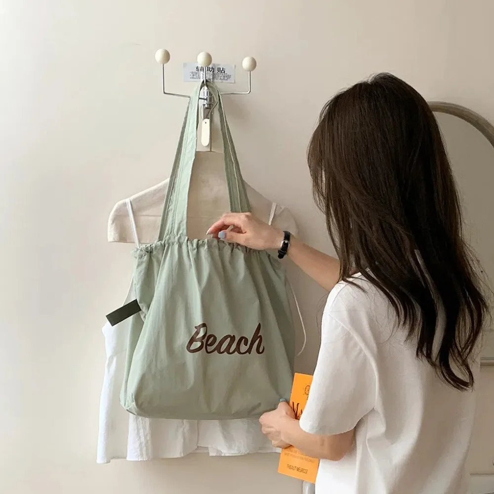 Polyester drawstring handbag with pleats large capacity nylon shoulder bag breathable Korean letter printed handbag school 241008