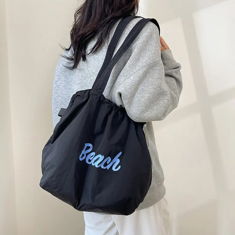 Womens Korean version letter printed canvas shoulder bag casual version commuting drawstring large capacity bag 241008