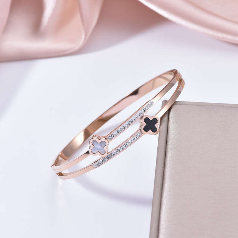 DH collections Korean - style Luxury - inspired Stainless Steel Bracelet. This bracelet with black - and - white four - leaf clover designs is fade - 