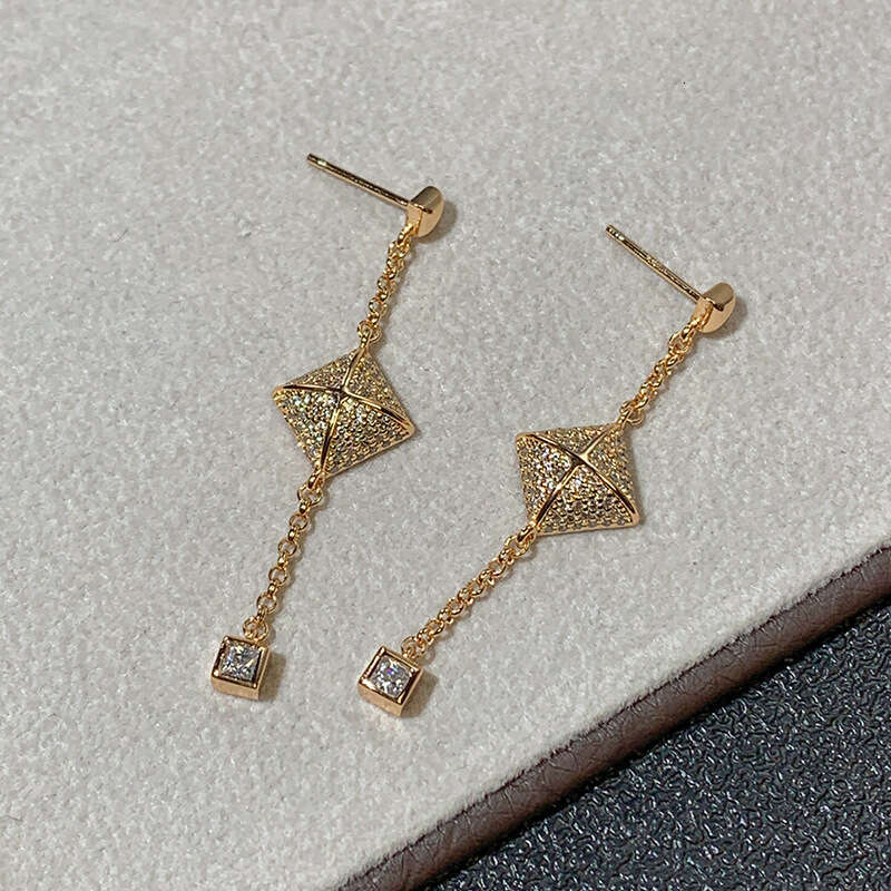 DHcollections Stylish V - Gold Women's Cross - Square Rivet Pendant Chain Earrings with Tassels. These V - Gold earrings feature a unique geometr