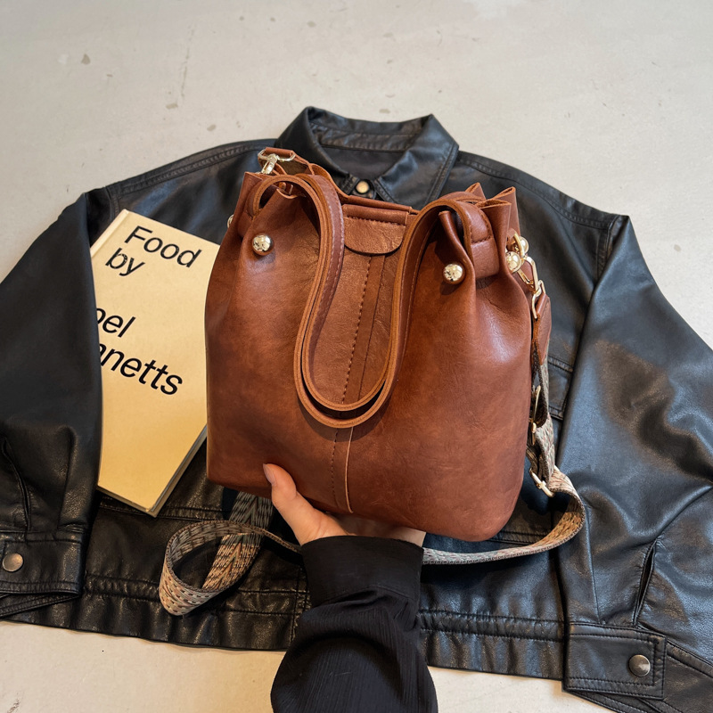 New autumn retro fashion simple texture bucket bag shoulder width design women s shoulder bag commuting bag autumn new designer bag women s crossbody 
