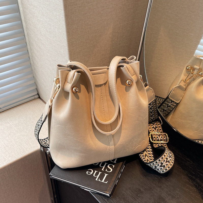 New autumn retro fashion simple texture bucket bag shoulder width design women s shoulder bag commuting bag autumn new designer bag women s crossbody 