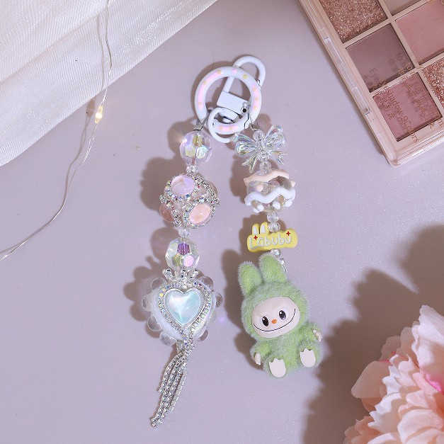 Adorable kid DIY makes a kid backpack with a keychain, a chain for hanging keys, a pendant for a girlfriend's phone, an alloy item with cute bead