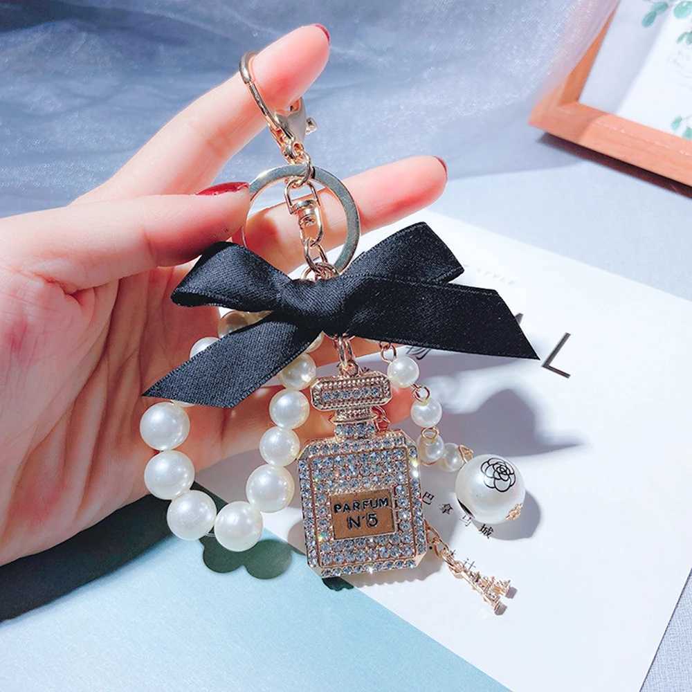 Keychains Lanyards Fashion Exquisite Key Chain Alloy Diamond Inlaid Bow Shaped Perfume Bottle Key Chain Creative Pearl Chain Bag Pendant Car Keychain D250924