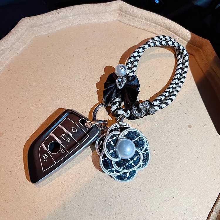 Fashion Exquisite Fashion Creative Weaving Small Fragrant Style Black and White Hand Rope Pearl Camellia Keychain Bag Pendant3 D250925