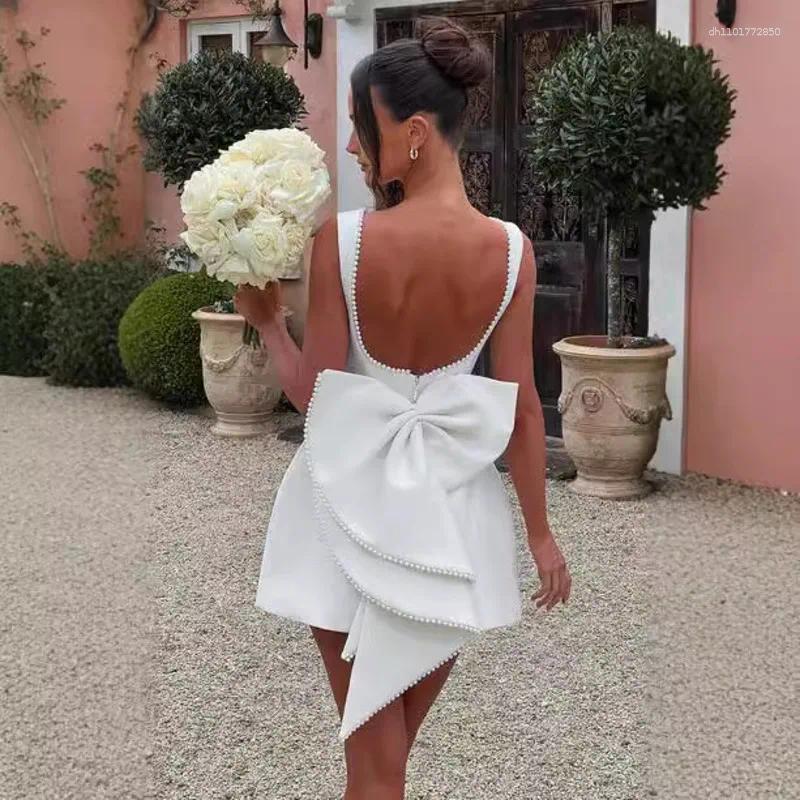 Elegant Backless Mini Dress: White Party Dress with Pearl Detail, Bow Accent & Corset Waist for Summer Beach or Wedding C260312