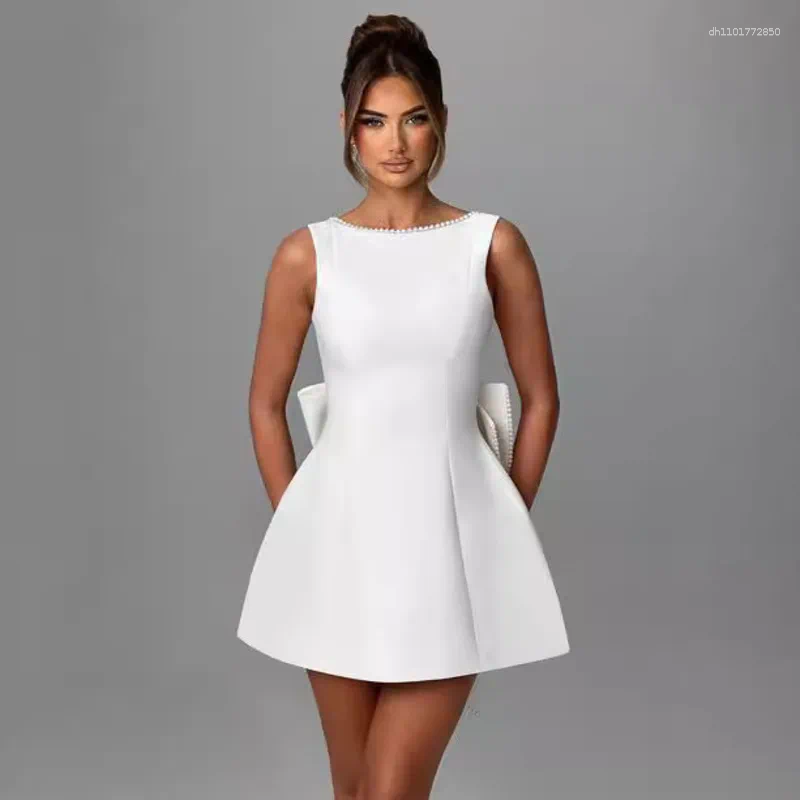 Elegant Backless Mini Dress: White Party Dress with Pearl Detail, Bow Accent & Corset Waist for Summer Beach or Wedding C260312