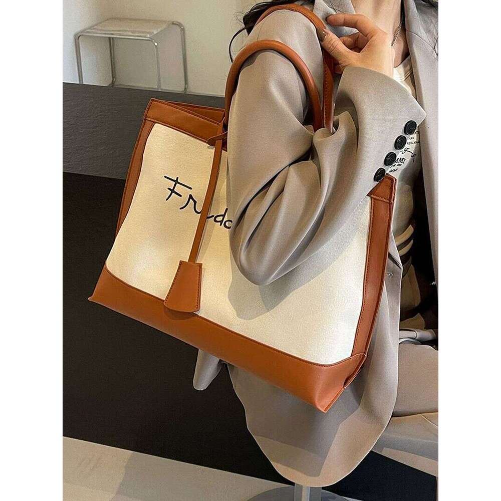 A niche designer canvas tote for women's 2024 new high-capacity commuting handheld shoulder bag
