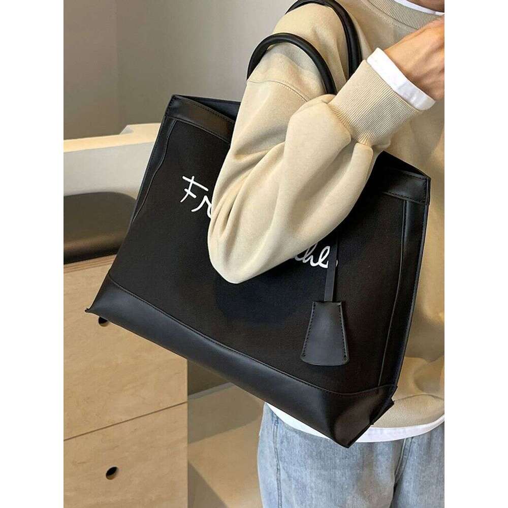 A niche designer canvas tote for women's 2024 new high-capacity commuting handheld shoulder bag