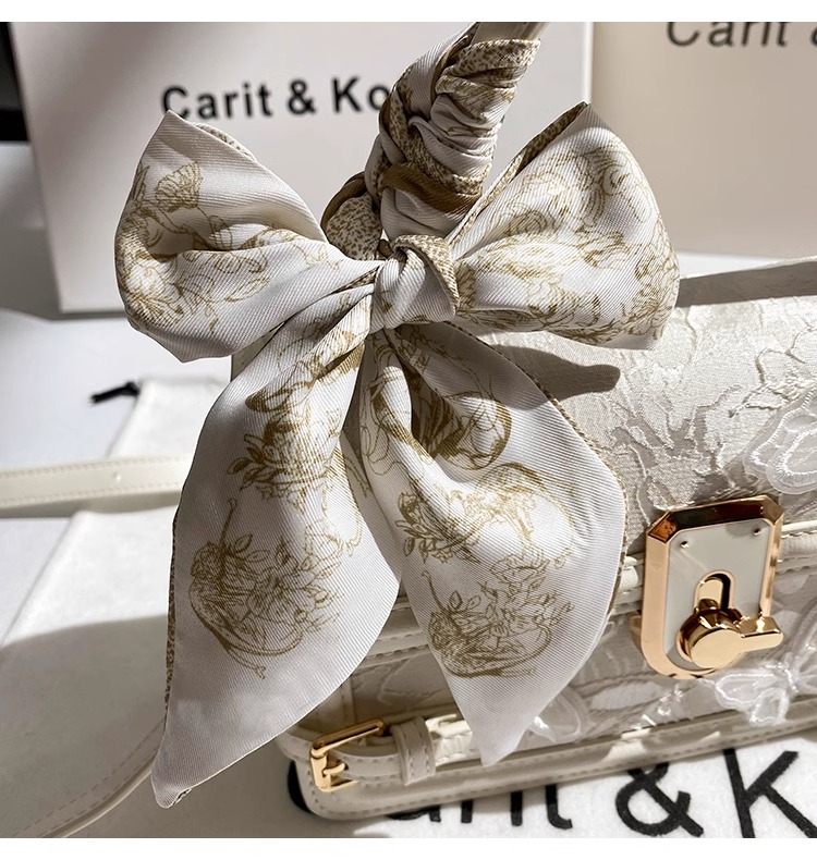 This handbag features intricate embossing and a chic striped ribbon Its gold clasp adds luxury Ideal for daily parties or banquets a global fashion st