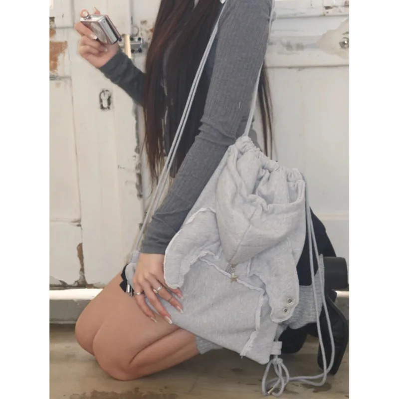 2025 Fashion Xzbag Korean Niche Angel Wing Backpack Simple And Versatile Drawstring Backpack Sweatshirt Hat Bag Y2k Girl Bag 250318