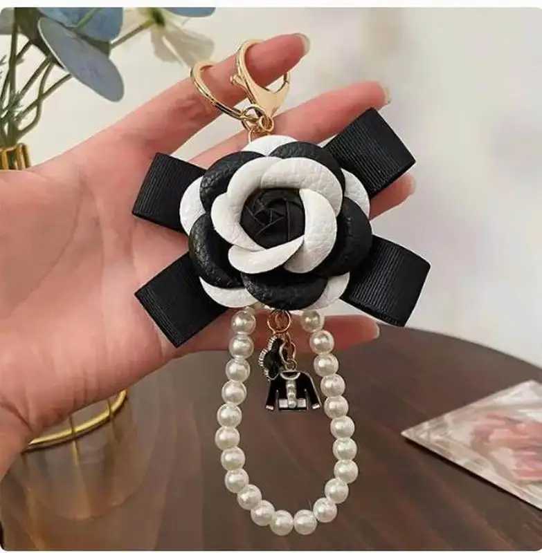 Cute synthetic PU leather rose camellia keychain suitable for women tripod keychain circular car bag pendant charm D467XJ250319