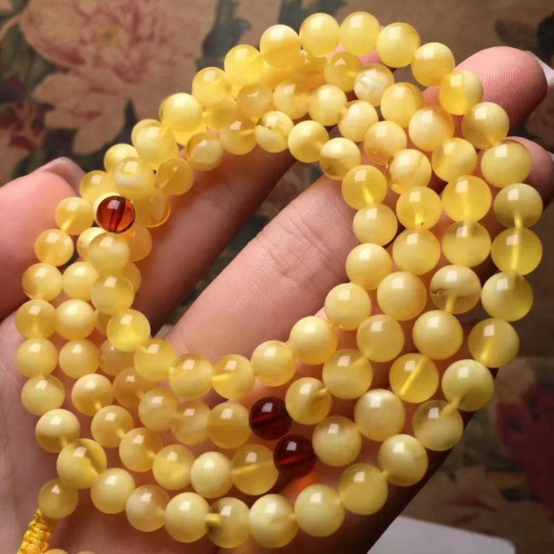The natural and exquisite Russian honey wax 108 Buddha beads feature a bracelet rich in golden white wax 250424