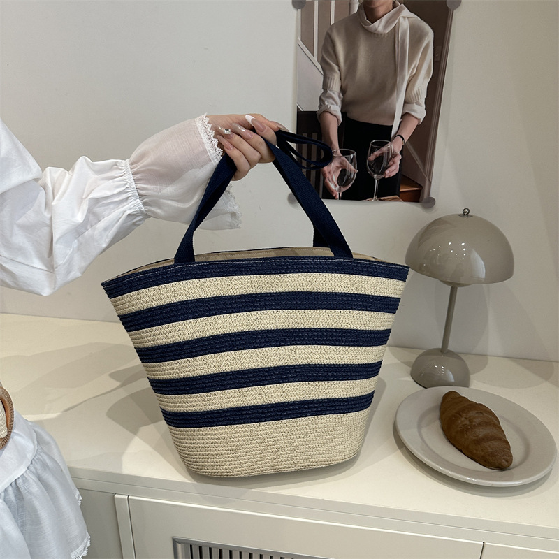 Color blocking hand-held bucket women's 2025 summer new item light luxury grass woven shoulder fashionable armpit bag