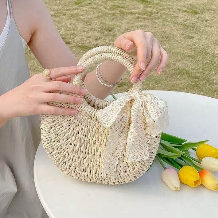 New spring and summer niche semi-circular grass woven leisure vacation style beach bag designer women's hand-held crossbody bag hollowed out tren